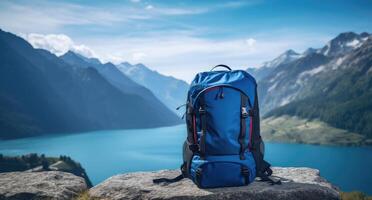 ai generado azul mochila en un montaña con montañas y lago en antecedentes foto