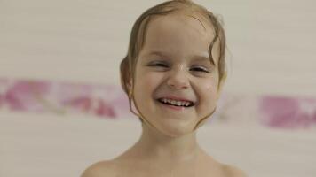 atractivo Tres años antiguo niña toma un baño. limpieza y Lavado pelo video