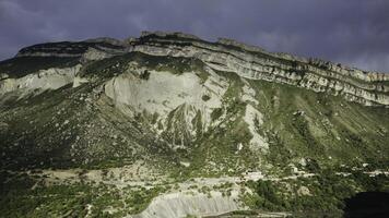 parte superior ver de montañas con arenoso acantilados acción. hermosa montaña con verde y rocoso laderas montaña con arenoso pendientes y verde arboles en verano foto