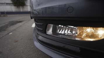 de cerca de faros de moderno coche modelo. acción. tiempo de día corriendo luces de nuevo coche. hermosa frente luces de nuevo coche en nublado clima foto