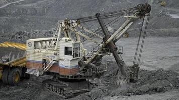 Mining excavator scooping up ore in a quarry. Close up of limestone mining. photo