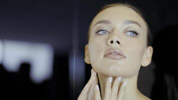 A woman after cosmetology services. Action. A person with bright blue eyes touches her body and face with her hands after massages and face masks. photo