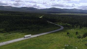 Aerial view of a long bending road and green meadow or field on cloudy sky background. Scene. Beautiful summer nature. photo