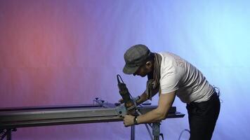 Man works at modern carpentry table. Creative. Modern carpentry table with fixing fasteners and cutters. Man is working with metal board on carpenter's table photo