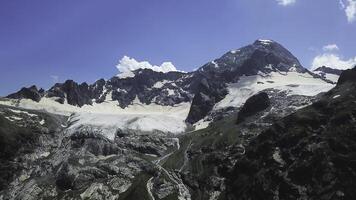 hermosa nevadas montañas en contra el azul cielo. parte superior ver de parte superior de montaña con nieve gorra foto