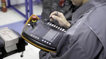 Worker uses touch control panel. Scene. Skilled worker uses electronic control panel in modern enterprise. Close-up of worker setting tasks on electronic control panel photo