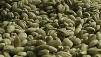 Close up of green coffee beans. Stock footage. Healthy food concept, a pile of premium Arabica green unroasted coffee beans lying on the flat surface. photo