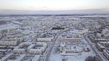 parte superior ver de ciudad en antecedentes de colinas en invierno. acortar. aéreo ver de moderno ciudad con de colores edificios y cubierto de nieve carreteras. panorama de ciudad con horizonte en invierno día foto