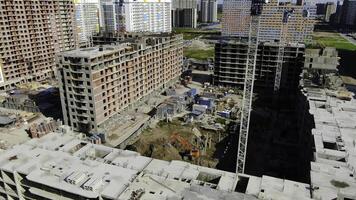 Top view of construction site of modern multi-storey building. Motion. Brick bare facade of multi-storey building under construction in modern landscaped area photo