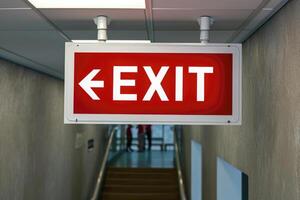 AI generated The Exit sign glowing in red shows the word EXIT to doorway. Generative AI. photo