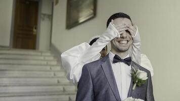 A couple of the bride and groom flirting with each other. Action. Smiling newlyweds filming in a building with bright lighting and decorations. photo