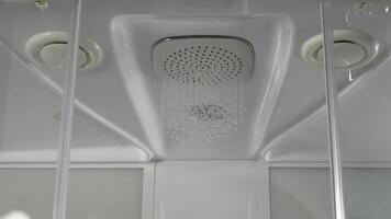 Running water of shower faucet. Shower head in bathroom with water drops flowing. Modern shower with water photo