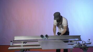 Man works at modern carpentry table. Creative. Modern carpentry table with fixing fasteners and cutters. Man is working with metal board on carpenter's table photo