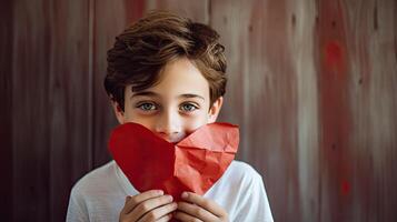 AI generated A shy little boy holding a paper heart shape and hiding behind it on wood background photo