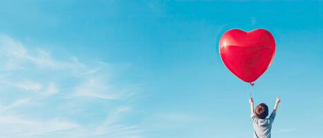 ai generado espalda ver de un niño levantamiento brazos con rojo amor enamorado corazón conformado globo en contra cielo antecedentes foto