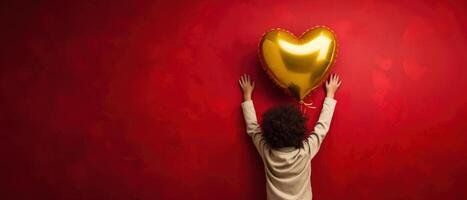 AI generated Rear view of a kid raising arms with gold yellow heart shaped balloon on red background photo