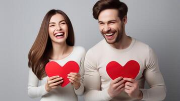 AI generated Young happy couple in love holding red paper heart isolated on grey background photo