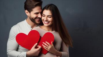 AI generated Young happy couple in love holding red paper heart isolated on grey background photo