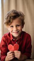 AI generated A little boy with a red paper heart shape on blur indoor room background photo