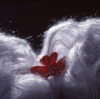 un cerca arriba de un blanco mullido pelo con un rojo flor foto