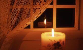 a candle is lit in front of a window photo