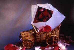 a basket with a card and rose petals on it photo