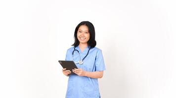 joven asiático hembra médico utilizando tableta para trabajo y sonriente aislado en blanco antecedentes foto