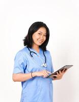 joven asiático hembra médico utilizando tableta para trabajo y sonriente aislado en blanco antecedentes foto