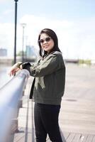 Young Beautiful Asian Woman Wearing Jacket And Black Jeans Posing Outdoors photo