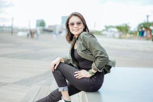 Young Beautiful Asian Woman Wearing Jacket And Black Jeans Posing Outdoors photo