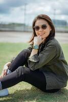 Young Beautiful Asian Woman Wearing Jacket And Black Jeans Posing Outdoors photo