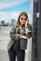 Young Beautiful Asian Woman Wearing Jacket And Black Jeans Posing Outdoors photo