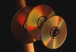 three cd's are shown in a dark room photo