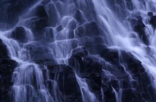 a waterfall is shown in the dark photo