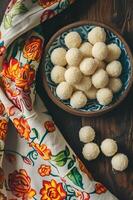 ai generado dulce elegancia beijinho Coco trufas en un estampado folklórico Manteles foto