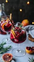 Glass filled with mulled wine, adorned with fresh citrus and rosemary, set against the backdrop of a twinkling Christmas tree, creating a festive and heartwarming holiday scene photo