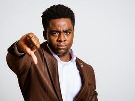 Portrait of young businessman who is angry and showing thumbs down. photo