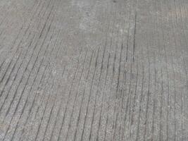 Striped texture of a concrete road in bright gray, photographed during the day photo