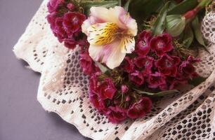 a bouquet of flowers on a lace tablecloth photo