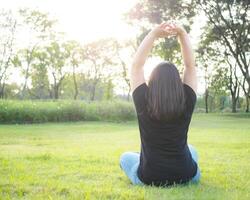 portrait young woman girl asian chubby cute beautiful long black hair one person wear black shirt  sitting with arms raised freely in garden park outdoor evening sunlight fresh happy relax sumer day photo