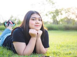 portrait young woman asian chubby cute beautiful one person   sleeping look hand holding use playing smart phone in garden park outdoor evening sunlight fresh smiling cheerful happy relax summer day photo