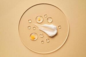 Gel, serum and a cream on a transparent round stand on a beige background. photo