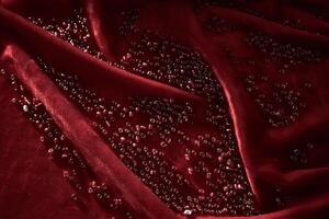 Abstract background from red beads on red velvet. photo