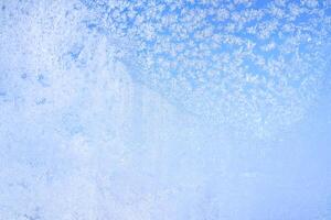 Abstract winter background. Frost on a frozen window against the blue sky. photo