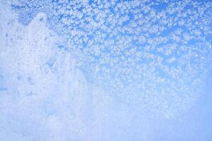 Abstract winter background. Frost on a frozen window against the blue sky. photo