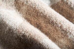 The texture of a warm sweater with a beige pattern. photo