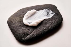 A smear of white cream on a black stone. photo