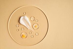 Gel, serum and a cream on a transparent round stand on a beige background. photo