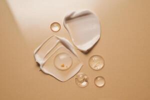 Gel, serum and a cream on a a beige background. photo