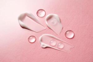 Gel, serum and a cream on a pink background. photo